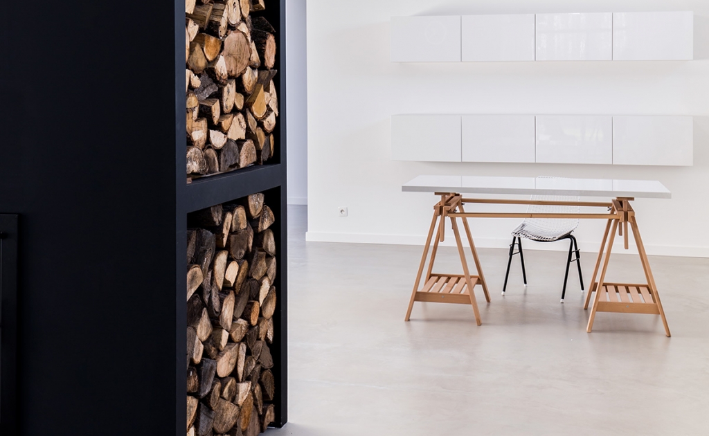 Simple interior in scandinavian style with white built-in kitchen cabinets and shelfs for wood storage